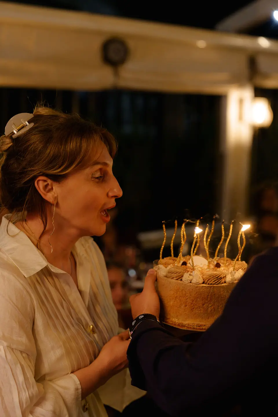 Guest with a celebration cake and lit candles